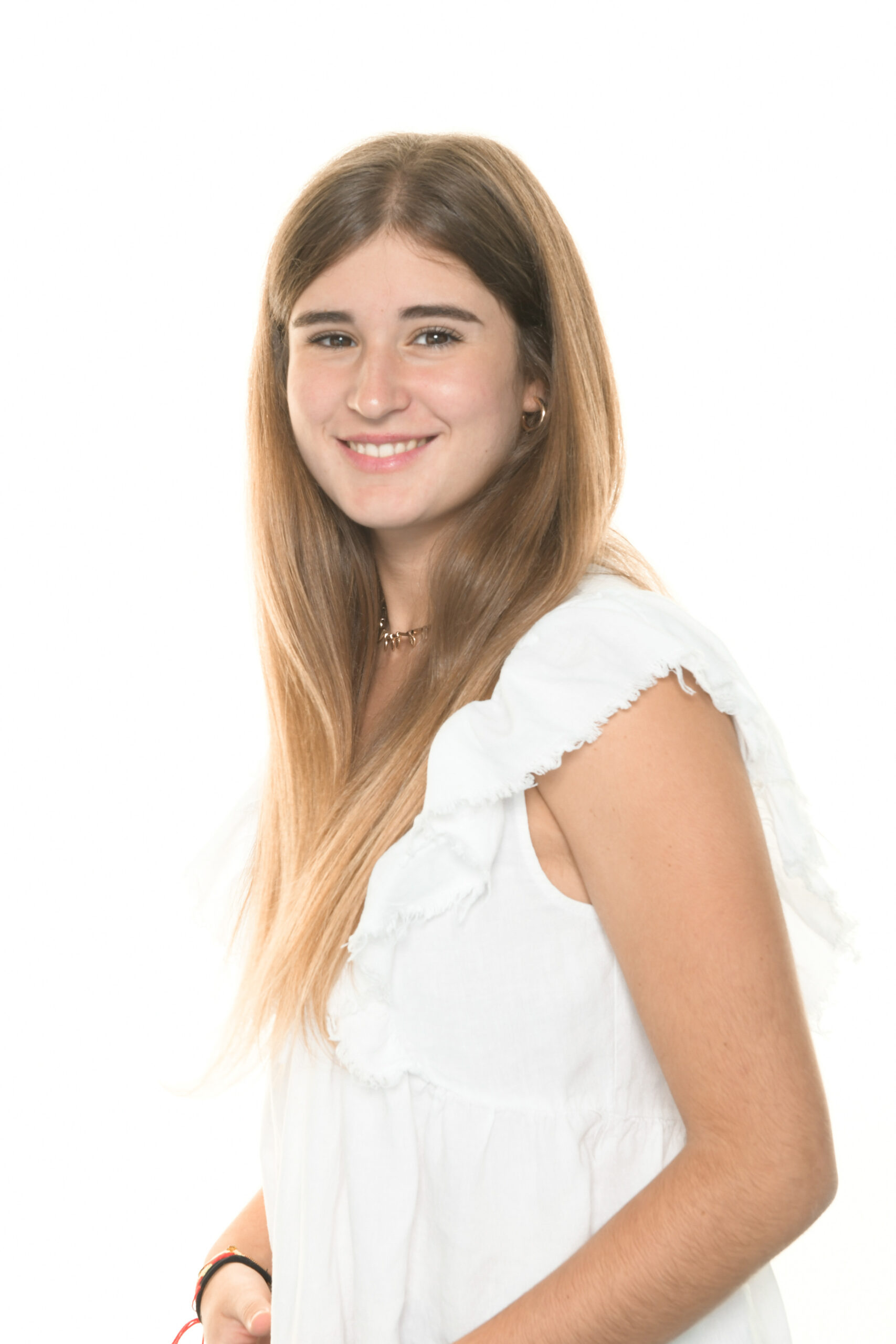 Retrato escolar de uma aluna sorridente com blusa branca sobre fundo branco